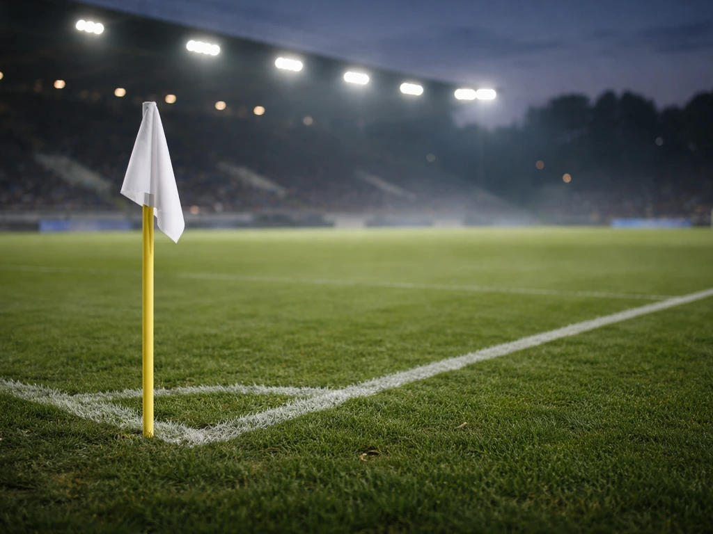 Dusk view of a soccer field with a corner flag and softly lit stadium atmosphere, minimal crowd blur.